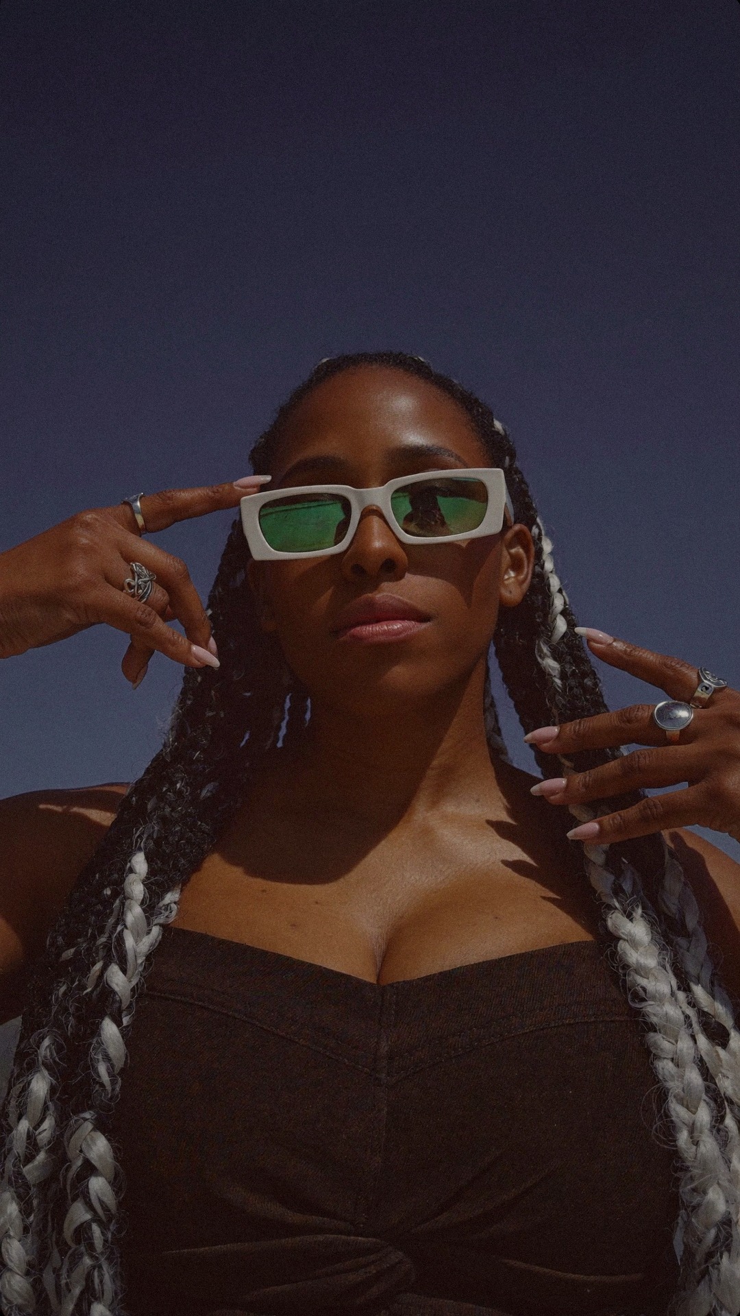 NELLA in profile against an oxblood sky